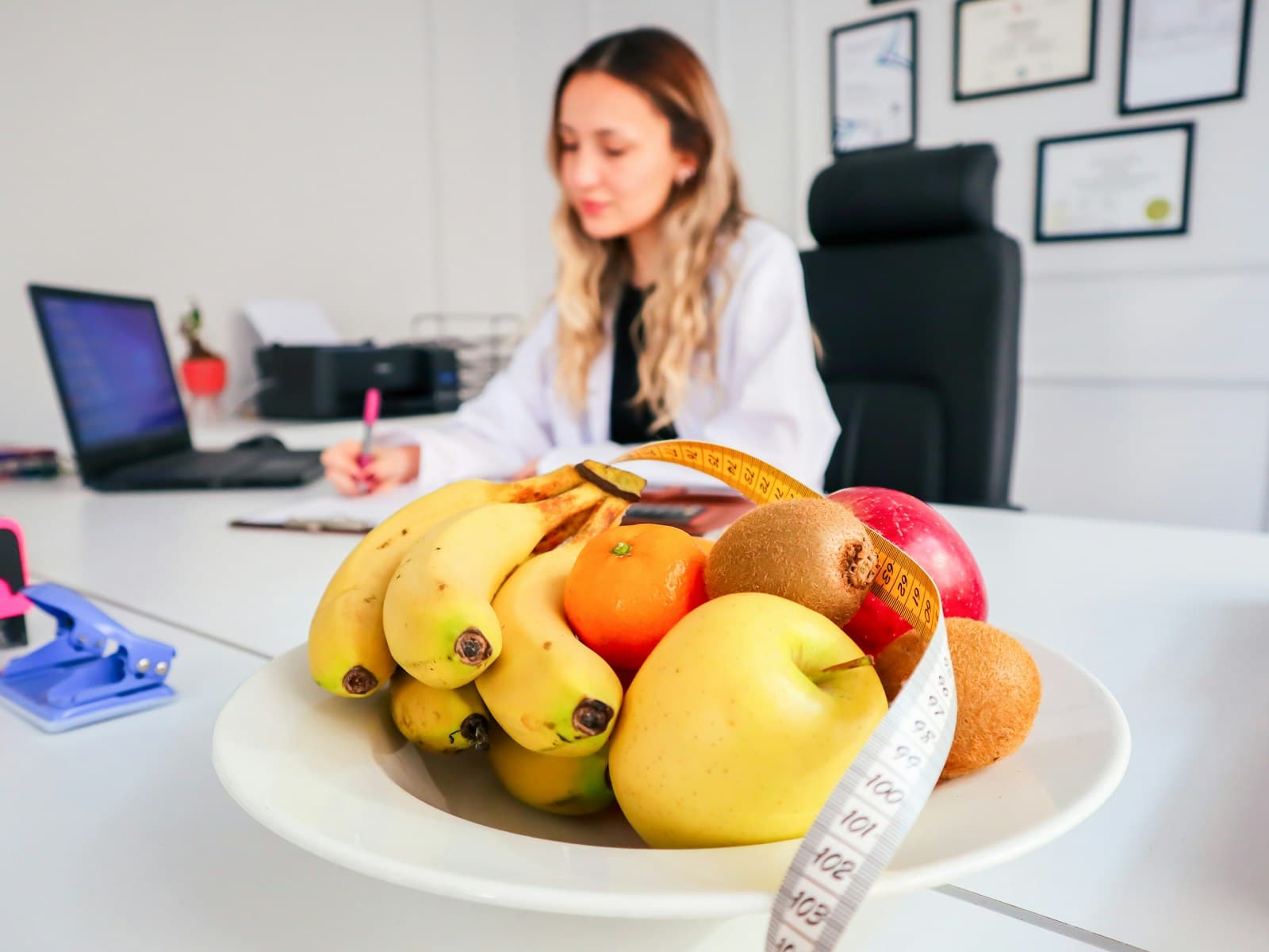 Consulta de nutrición clínica: sobre el escritorio hay un frutero y una cinta métrica junto a la historia del paciente.