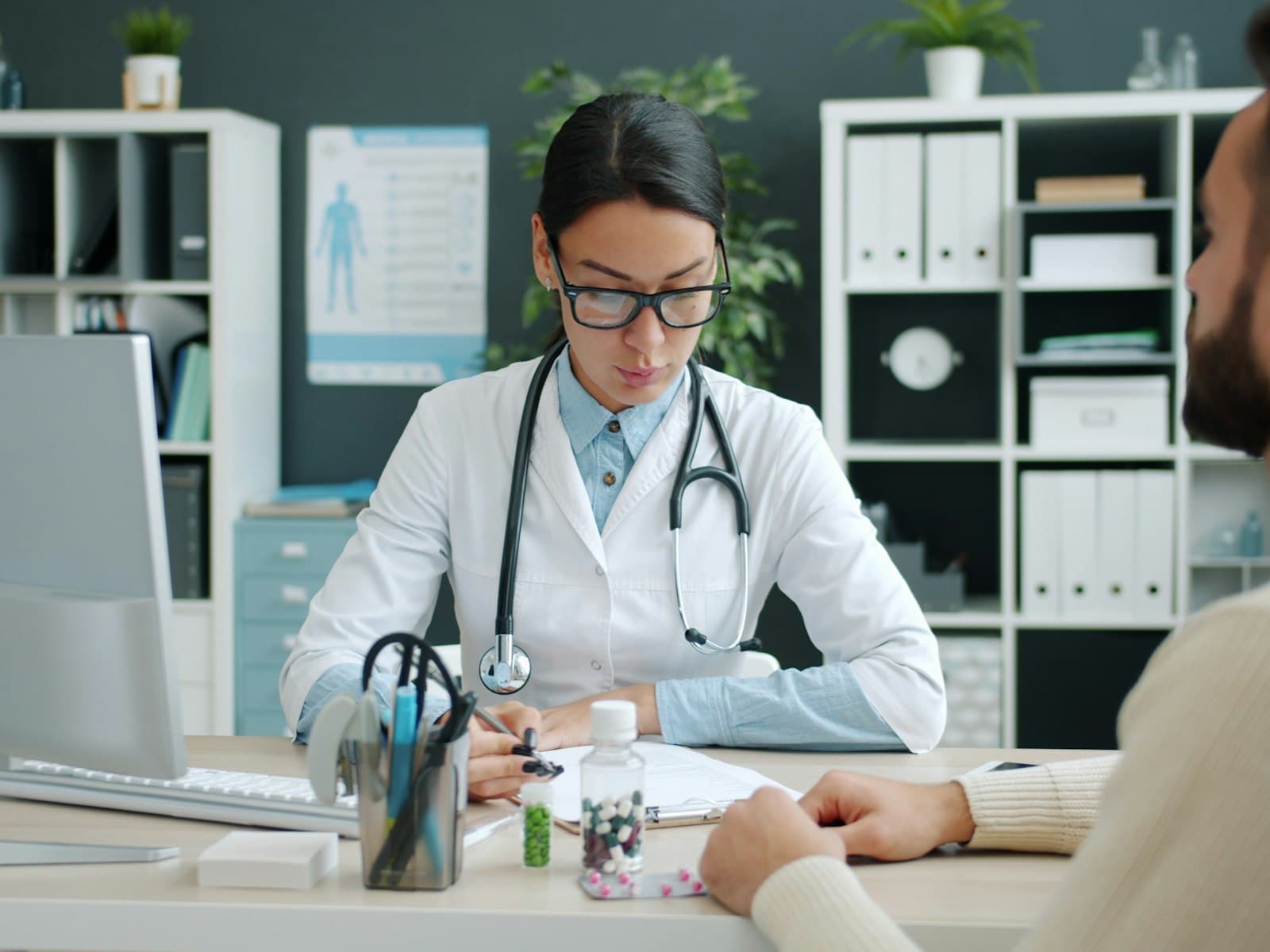 Consulta médica en un consultorio: una profesional de la salud atiende a una paciente y registra la información de la consulta.